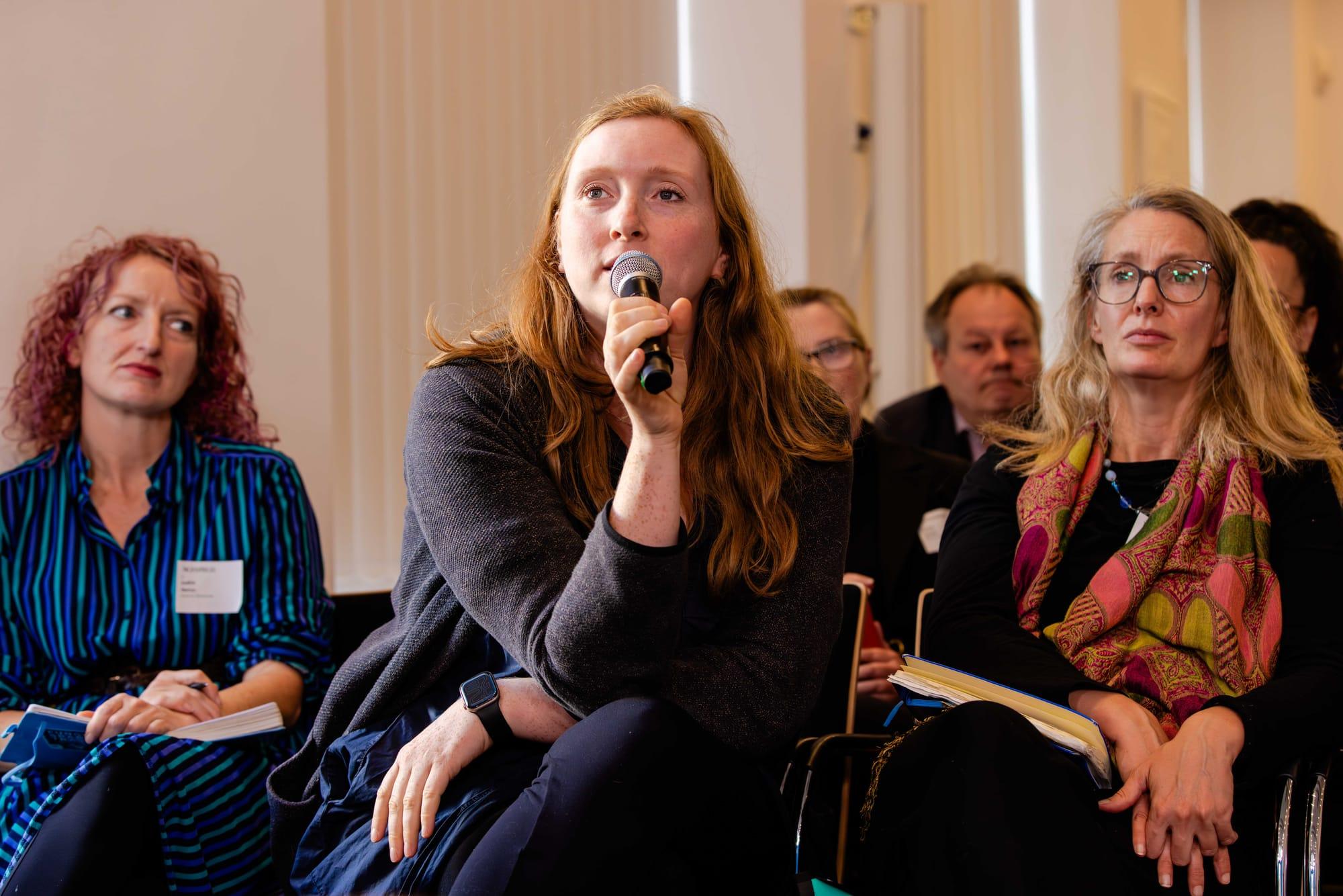 Person hält ein Mikrofon während einer Fragerunde im Publikum bei der Future Sustainability Week
