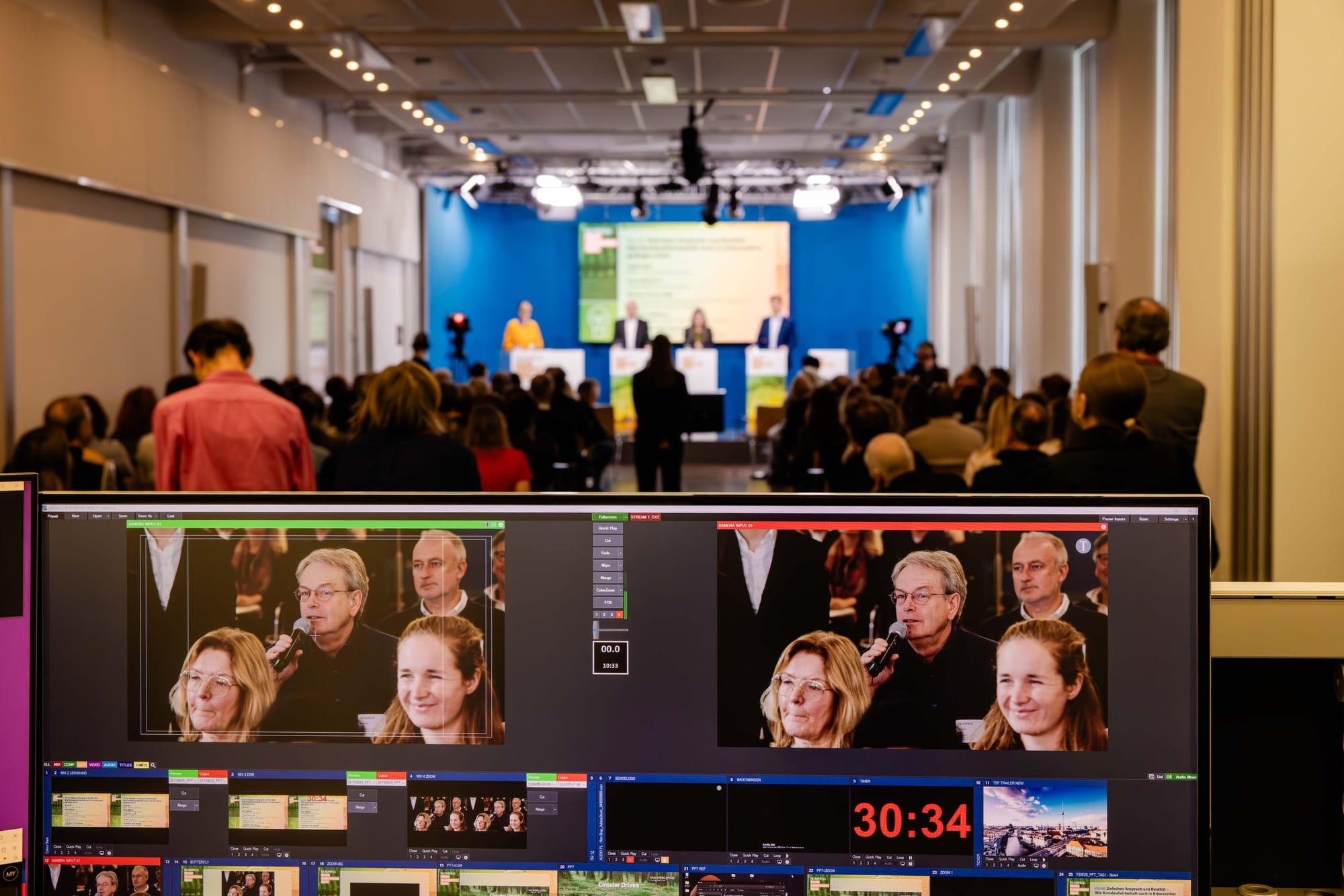 Regieraum mit Monitoren zeigt Livestream der Podiumsdiskussion bei der Future Sustainability Week
