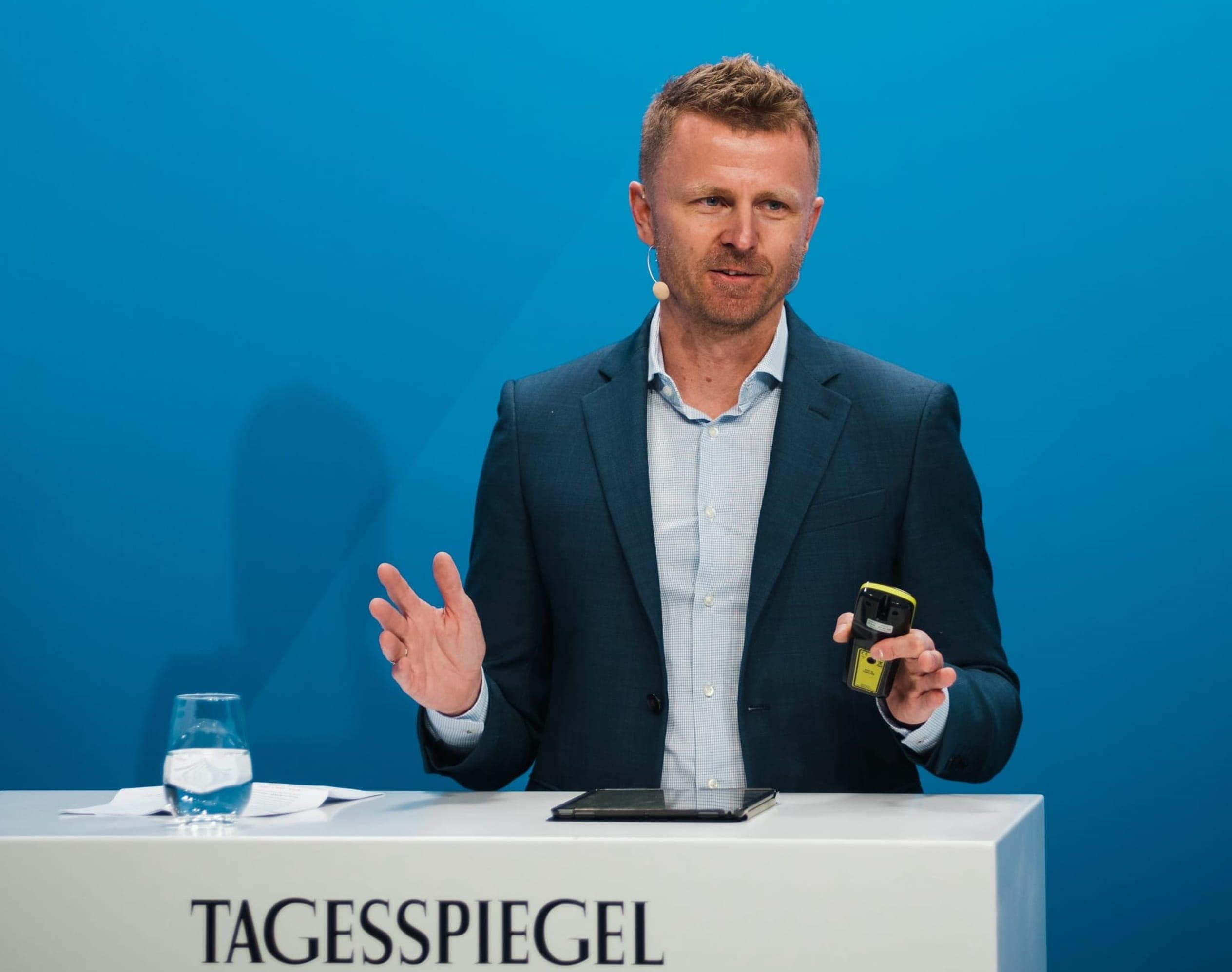 Eine Person steht hinter einem Rednerpult.