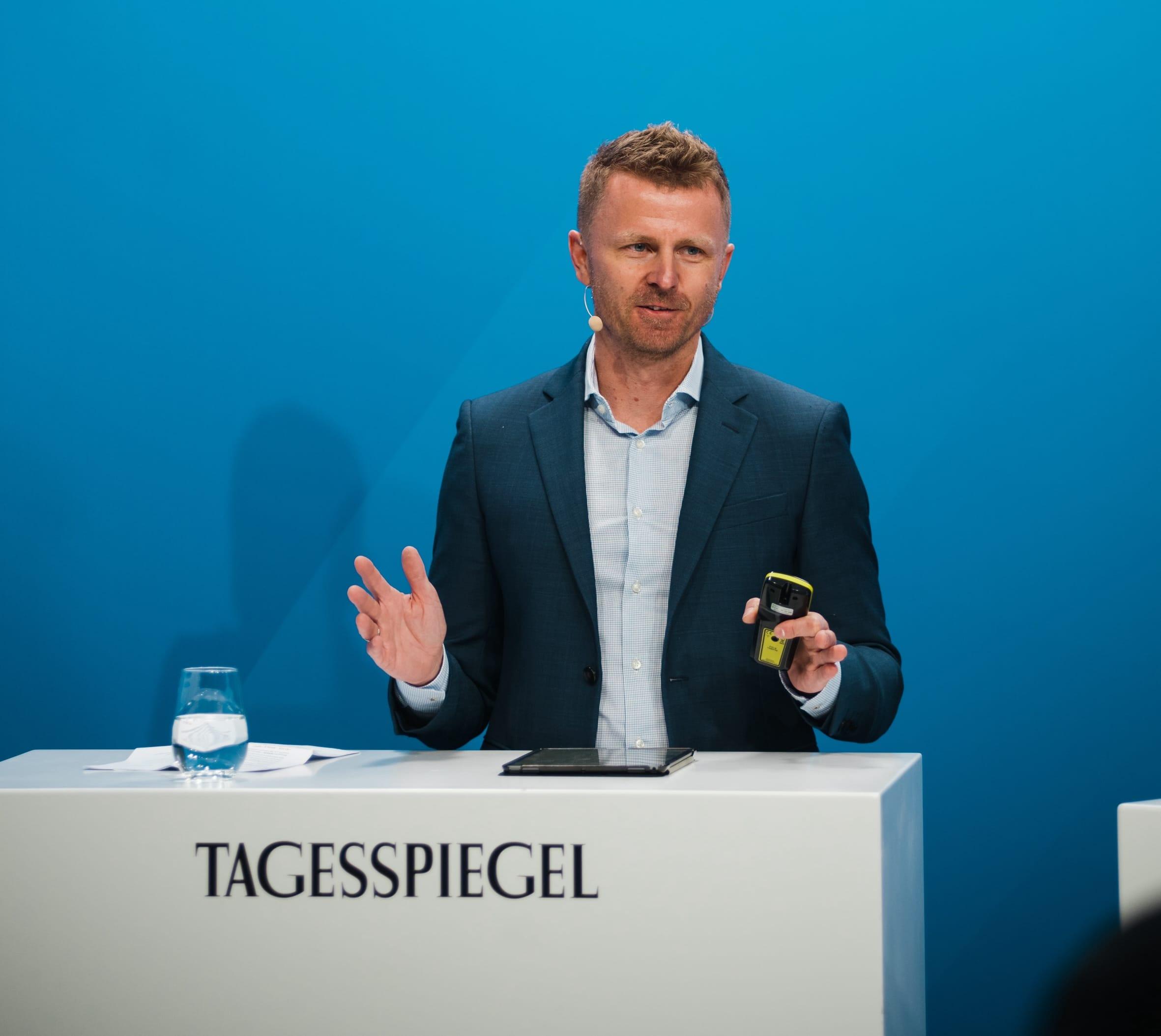 Eine Person steht hinter einem Rednerpult.
