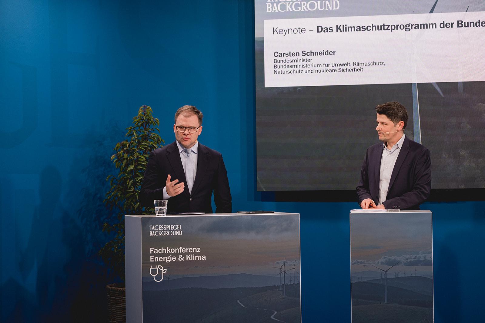 Publikum sitzt in Reihen und hört einer Präsentation aufmerksam zu.