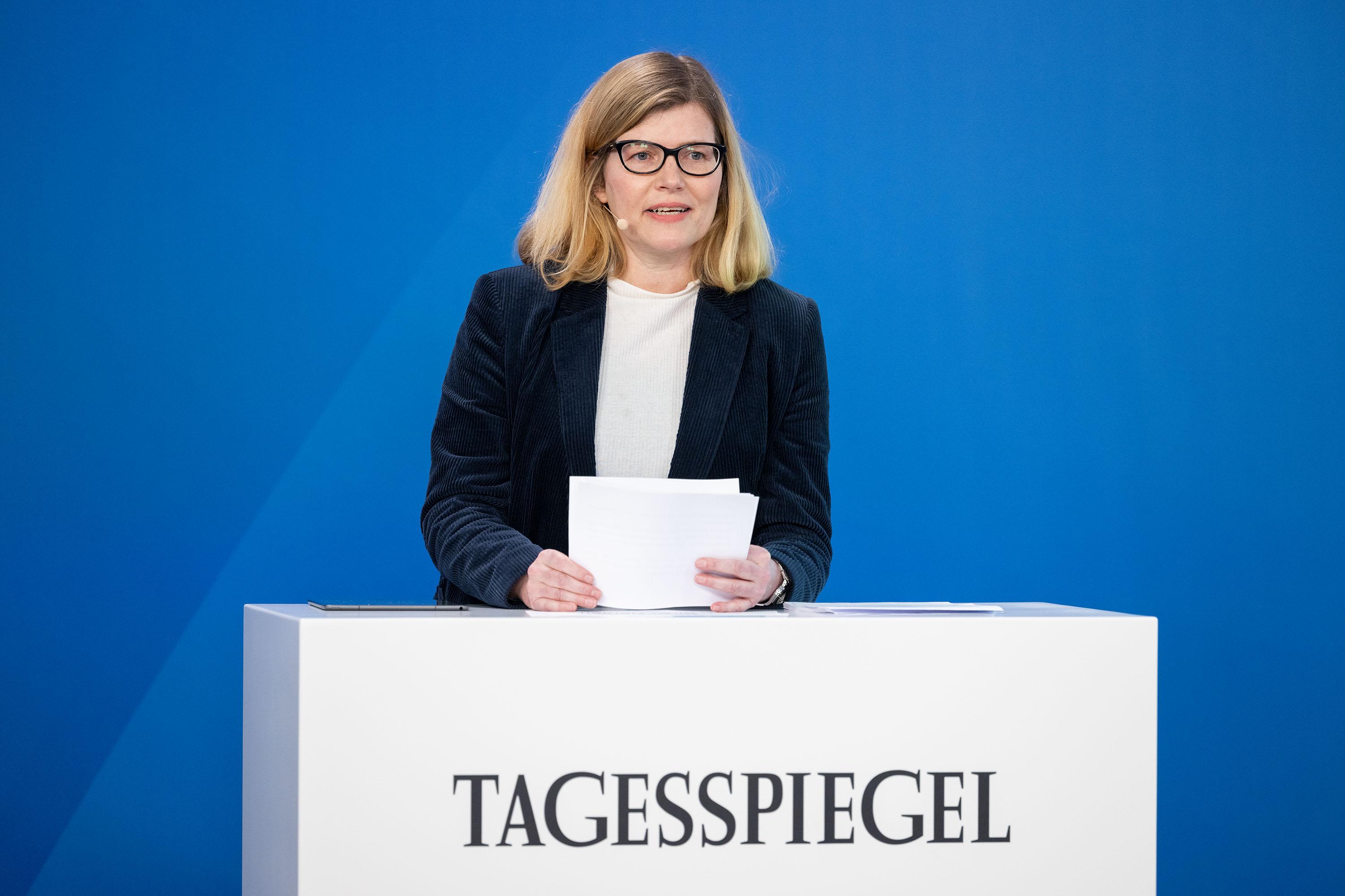 Eine Person steht hinter einem Rednerpult.