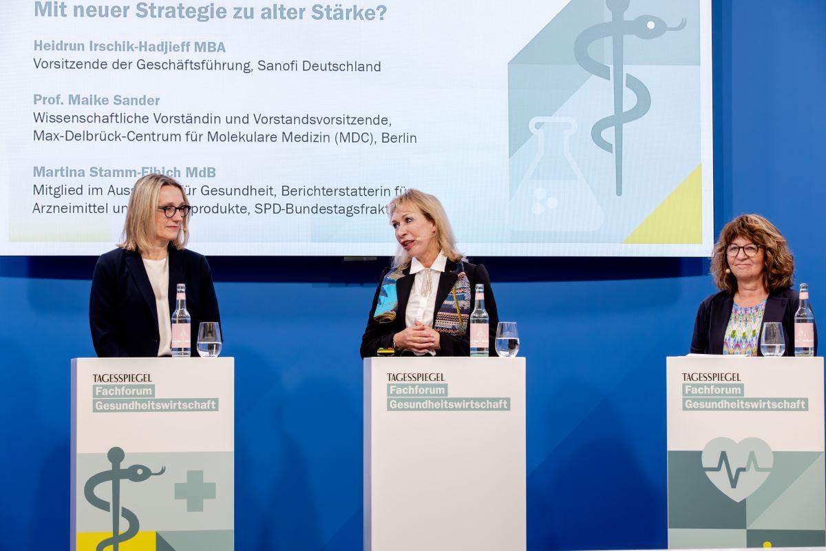 Drei Frauen stehen jeweils hinter einem Rednerpult. Im Hintergrund ist ein Screen.