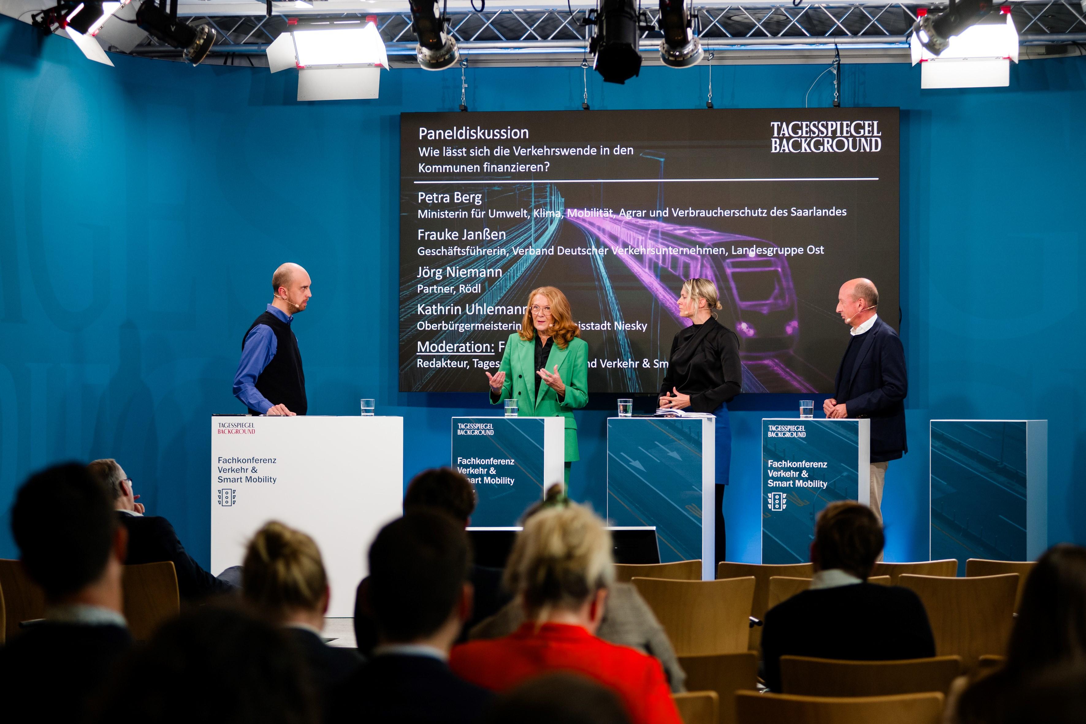 Vier Personen diskutieren auf der Bühne.