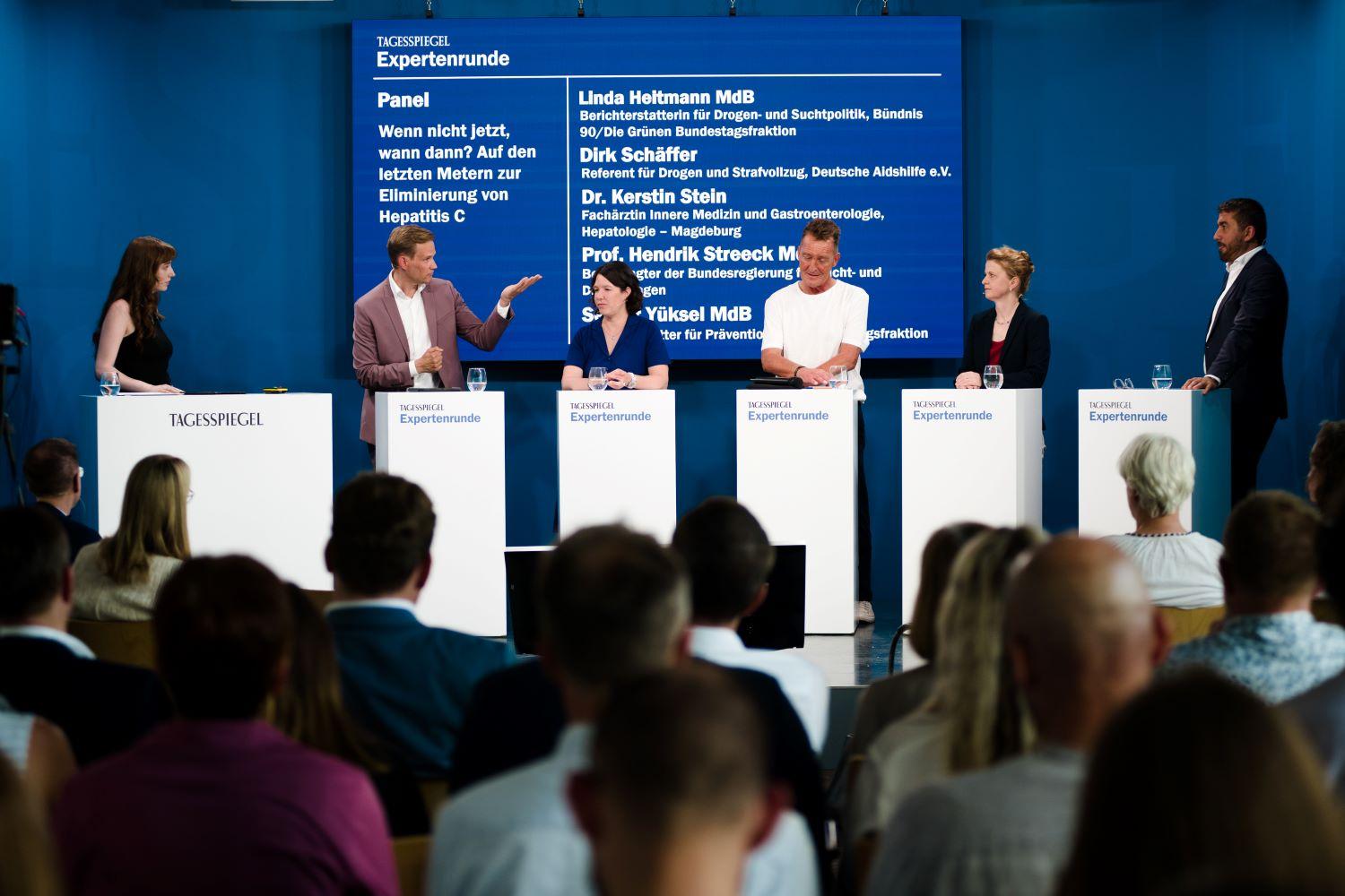 drei Frauen und drei Männer auf Bühne mit blauem Hintergrund