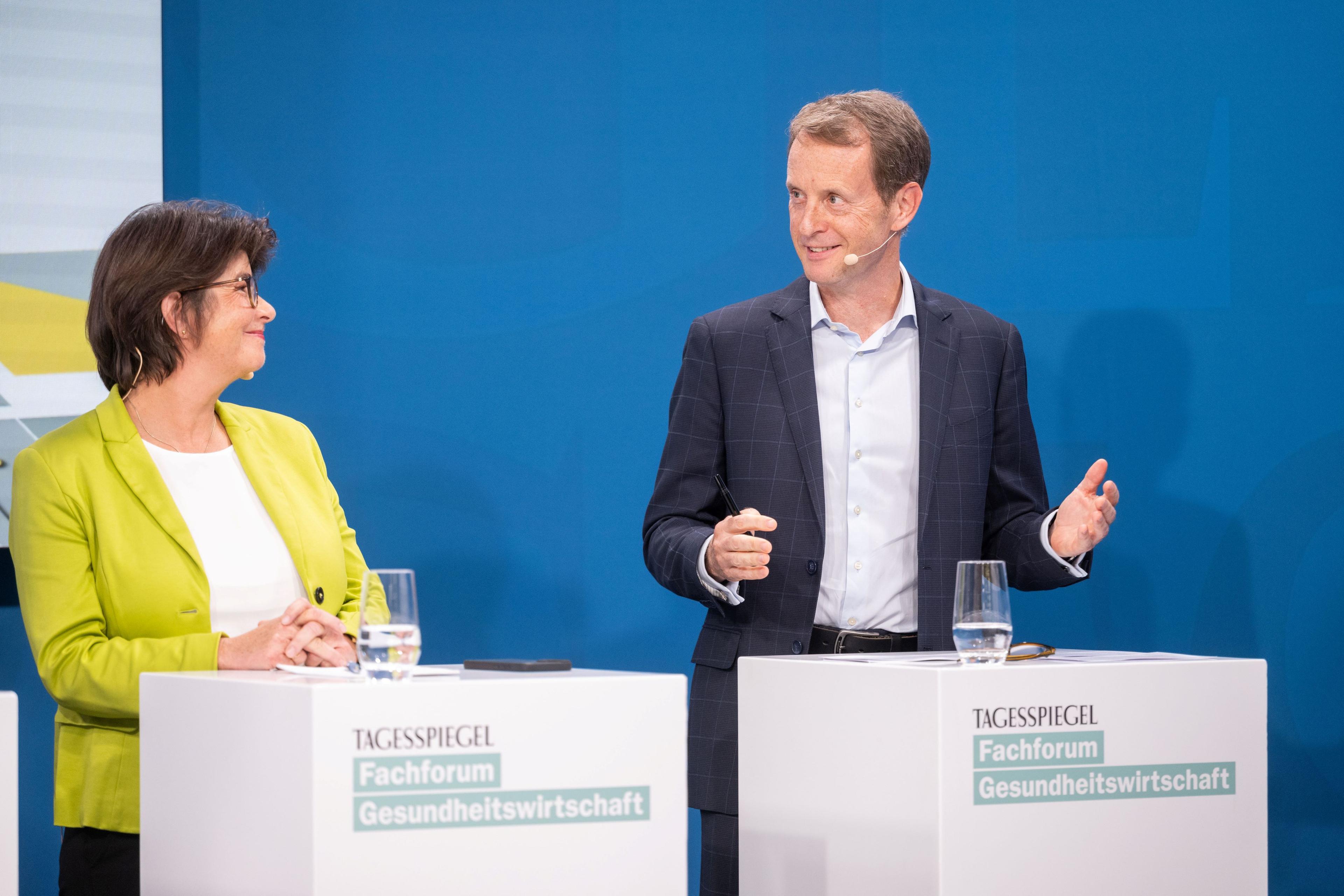 Zwei Personen diskutieren auf Bühne beim „Tagesspiegel“-Forum zur Gesundheitswirtschaft.