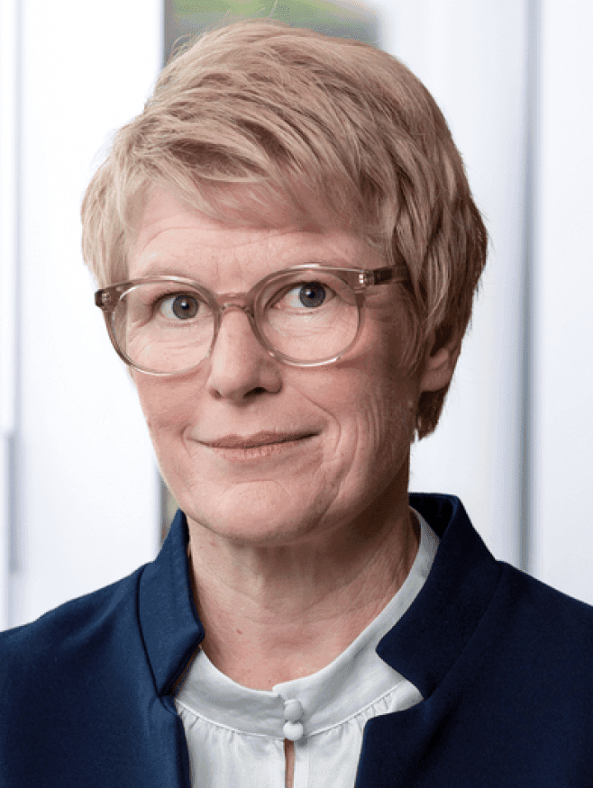 Eine Frau mit kurzen blonden Haaren, die eine Brille trägt.