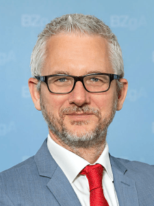 Ein Mann mit kurzen Haaren, der einen Anzug trägt.