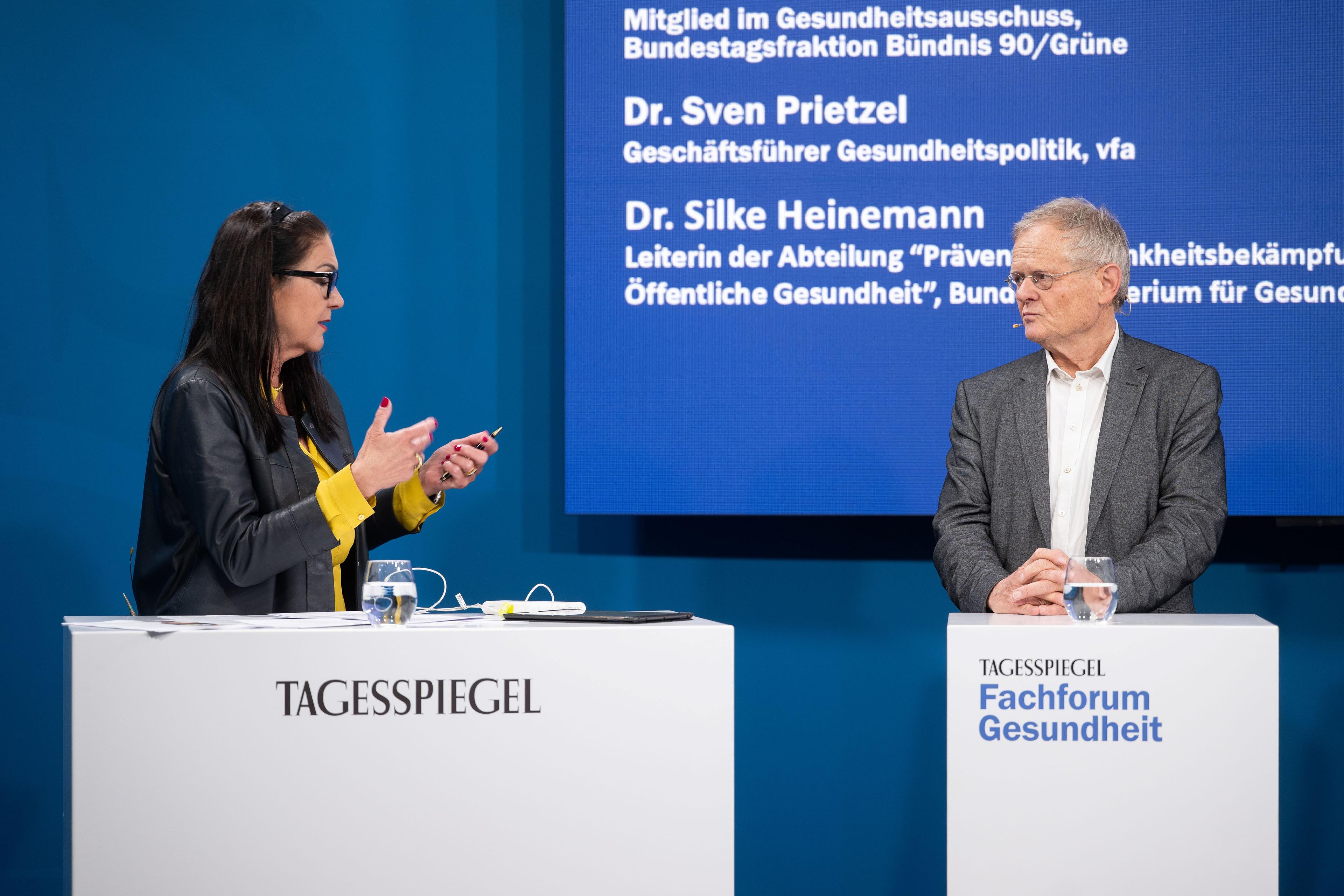 Moderatorin und Podiumsgast im Gespräch beim Tagesspiegel Fachforum Gesundheit auf blauer Bühne.