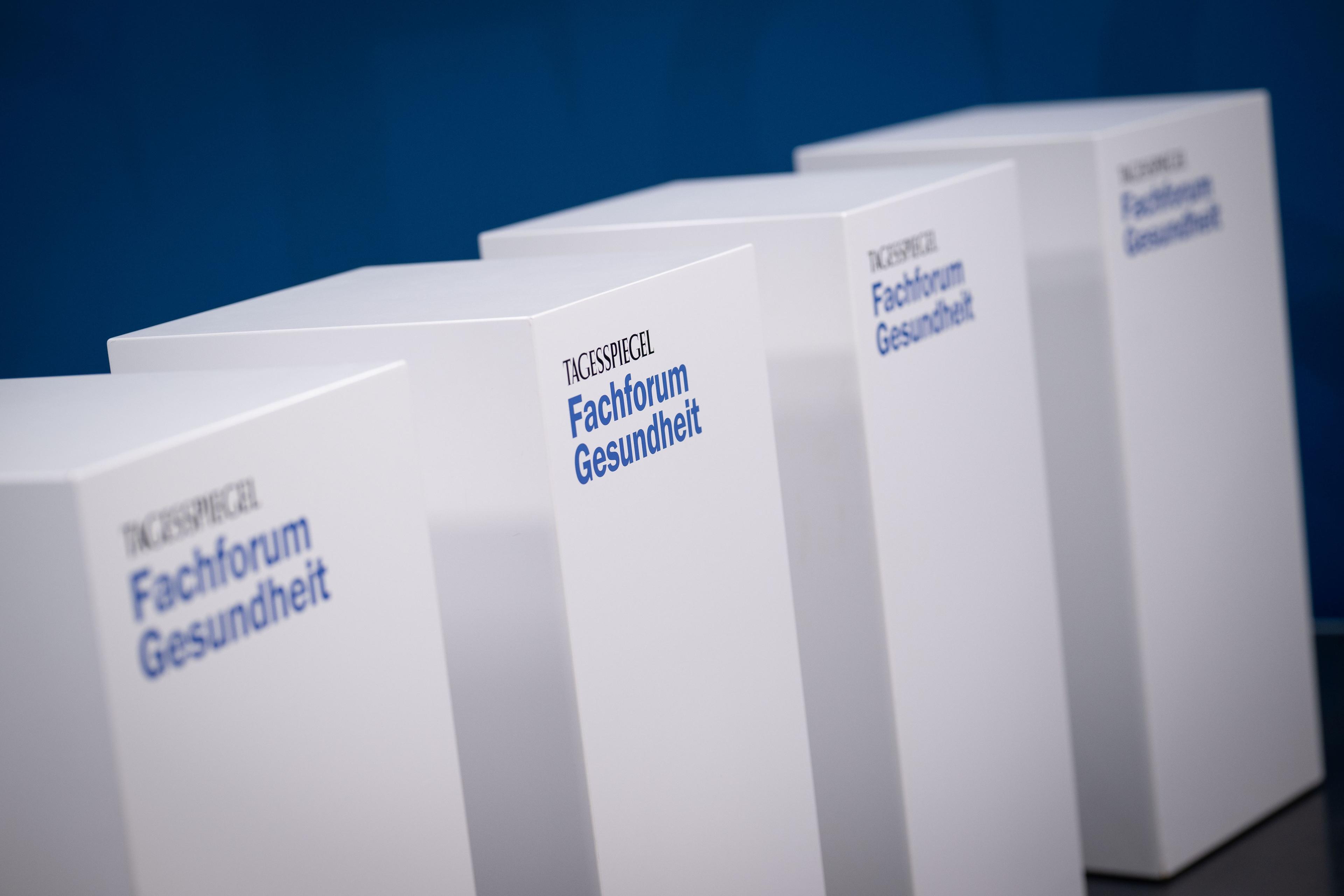 Rednerpulte mit dem Logo des Tagesspiegel Fachforums Gesundheit vor blauem Hintergrund.