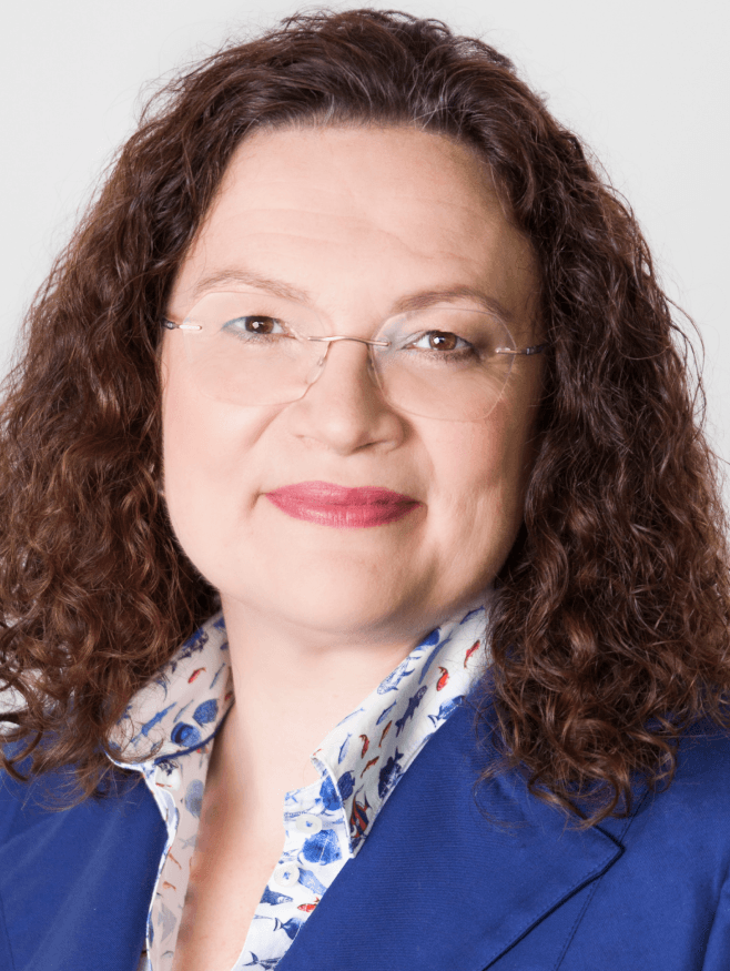 Eine Frau, die schulterlange Haare und eine Brille trägt.