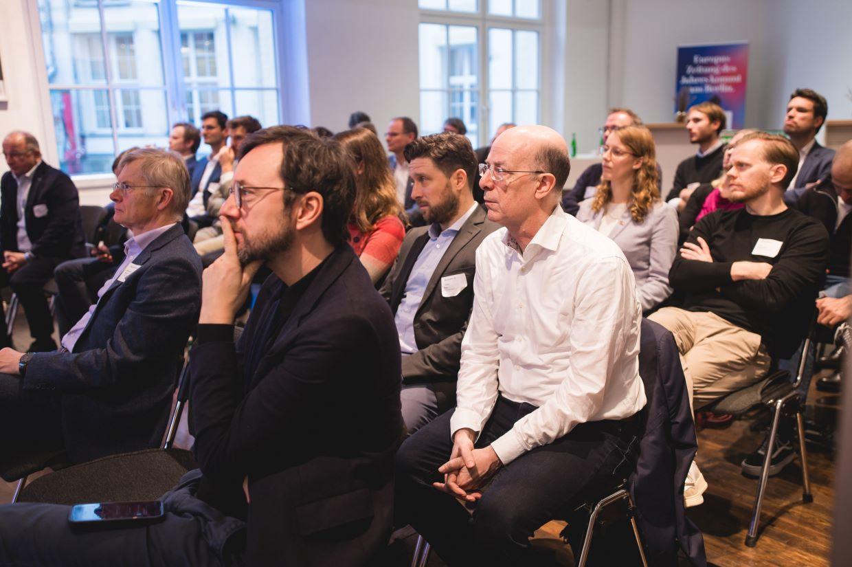 Sitzendes Publikum hört konzentriert zu.