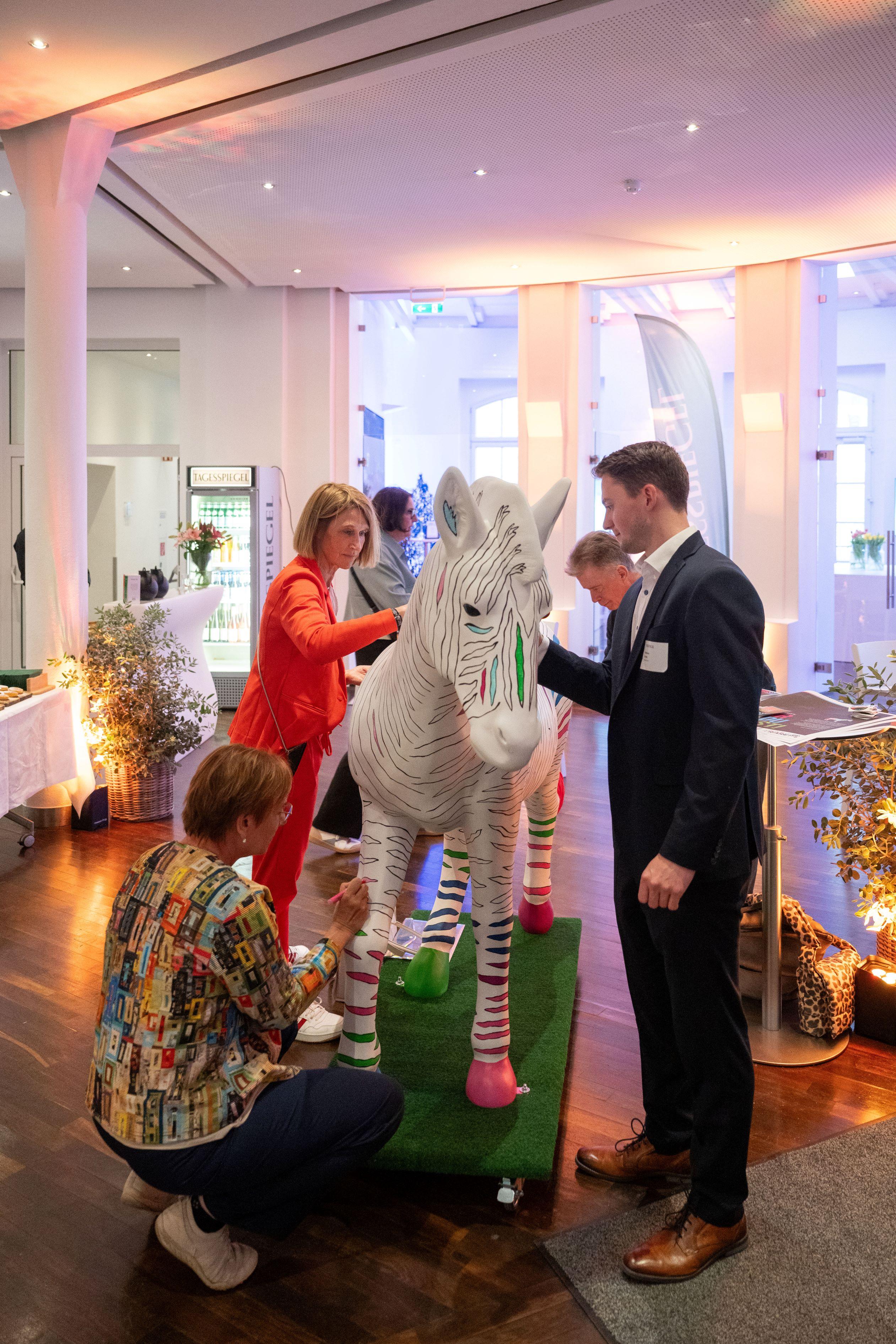 Personen malen ein weißes Zebra an.