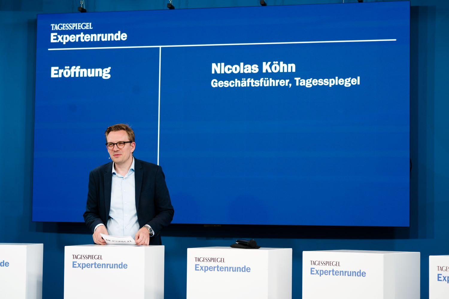 Mann auf Bühne mit blauem Hintergrund