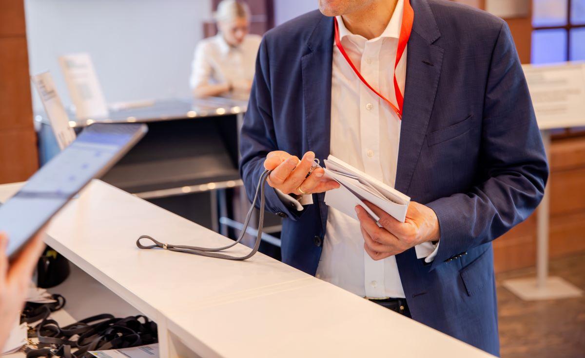 Eine Person hält am Empfang Namensschilder in der Hand.