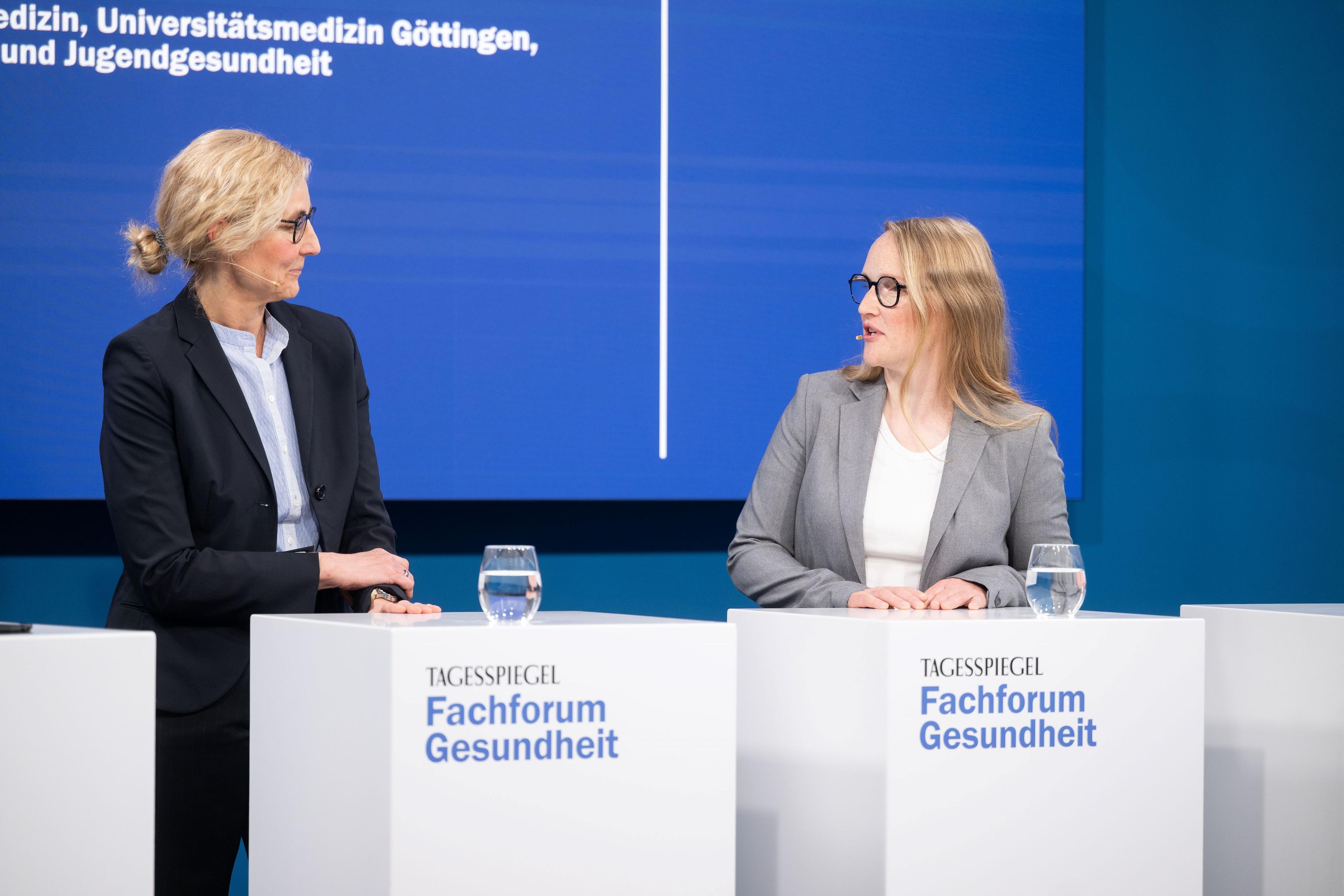 Zwei Frauen im Gespräch an Rednerpulten beim Tagesspiegel Fachforum Gesundheit.