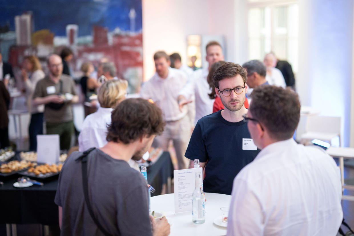 Teilnehmende sprechen am Stehtisch beim Get-Together Digitale Gesundheit.