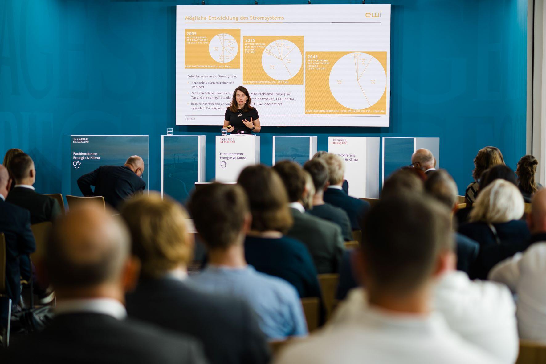 Referentin erläutert vor Publikum eine Präsentation zum Stromsystem.