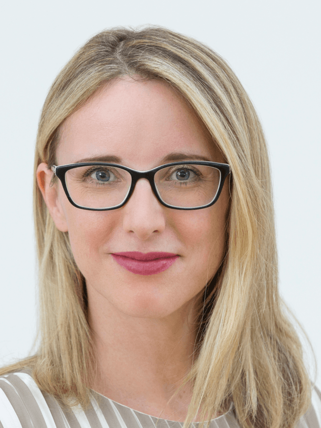 Eine Frau mit blonden langen Haaren, die eine Brille trägt.