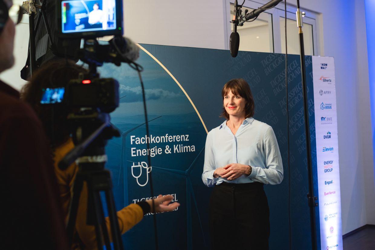 Podiumsdiskussion mit vier Personen vor blauem Hintergrund.