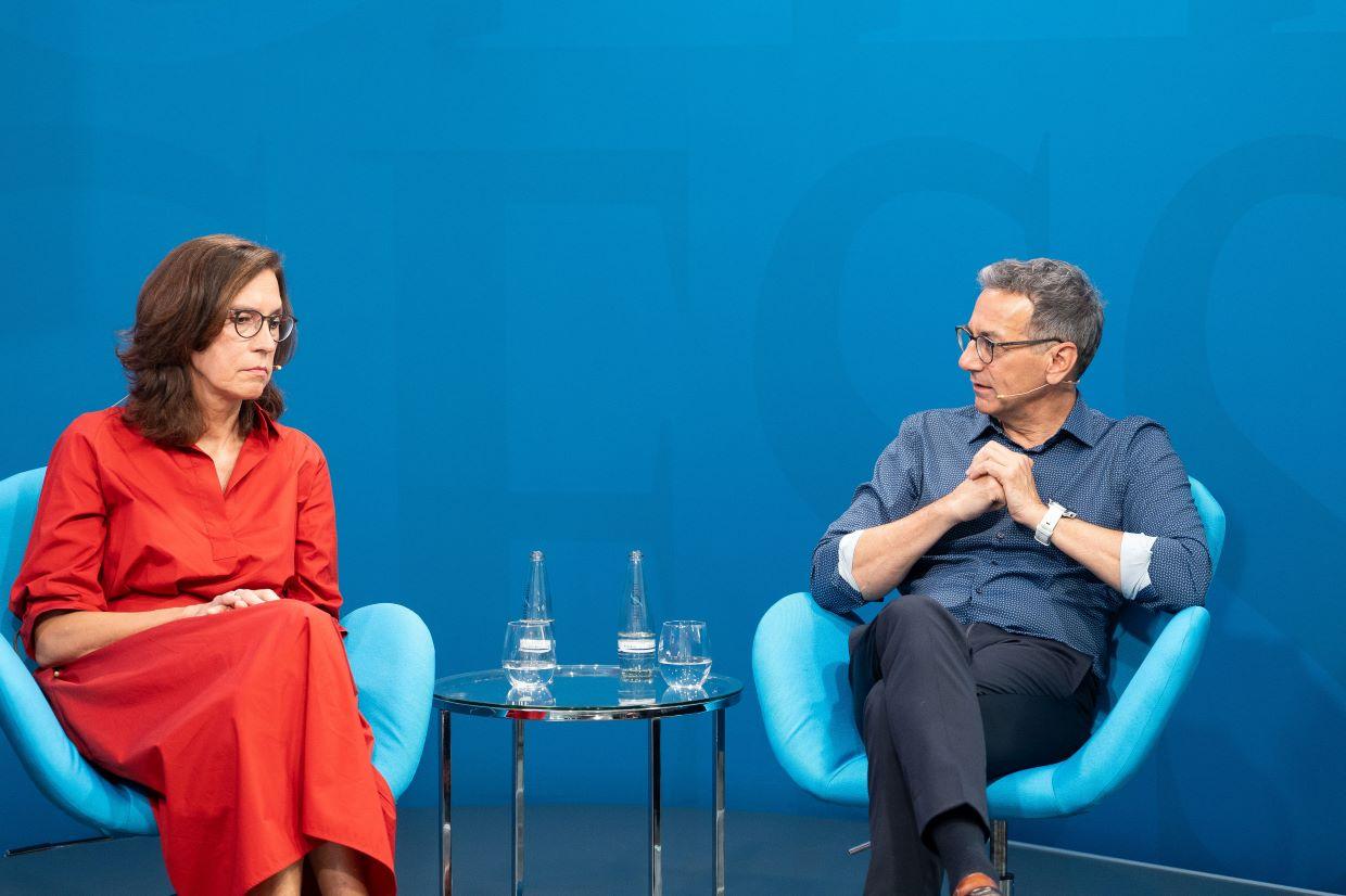 Zwei Panelgäste sitzen im Gespräch auf blauen Sesseln zur digitalen Gesundheit.