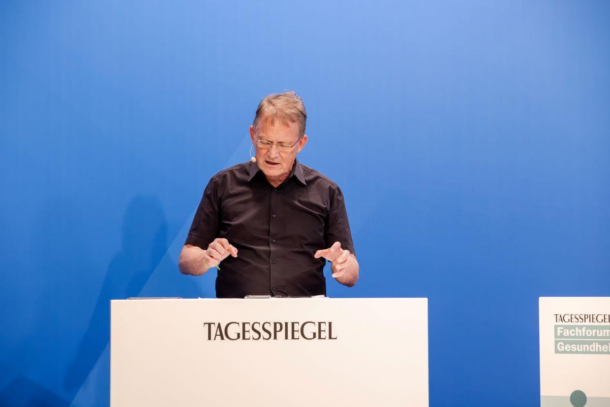 Hinter einem Rednerpult steht ein Mann.