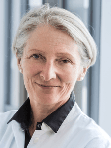 Eine Frau mit kurzen Haaren, die eine Bluse trägt.