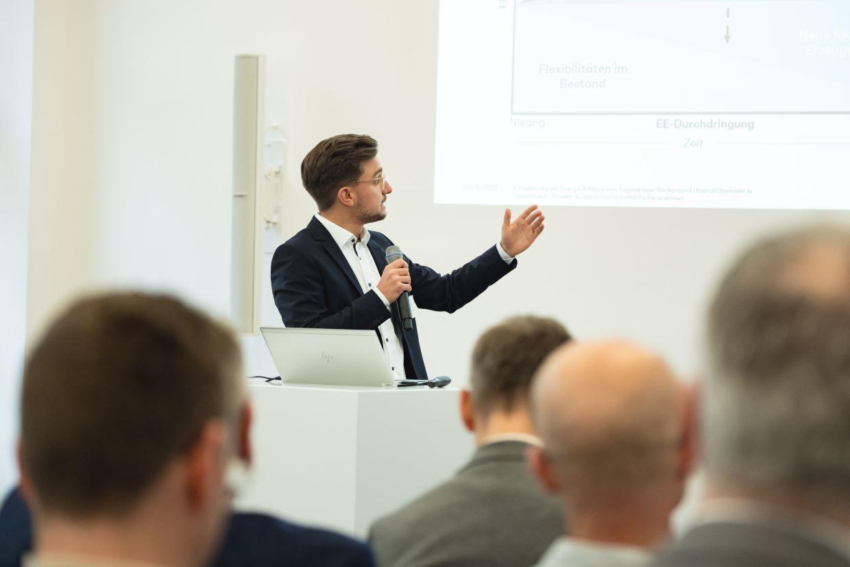 Präsentation mit Mikrofon, Grafik auf Leinwand.