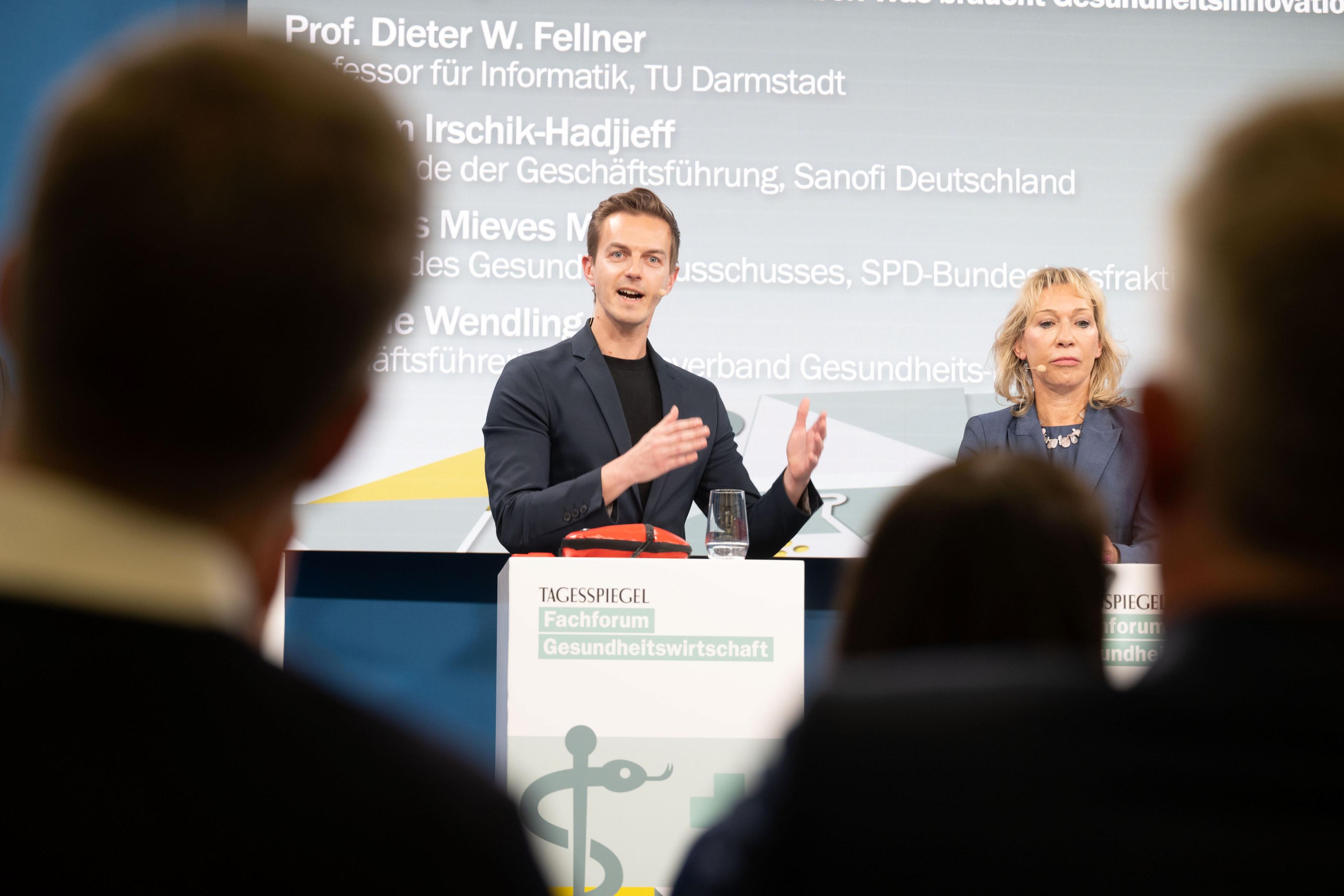 2 Personen sprechen beim „Tagesspiegel“-Fachforum zur Gesundheitswirtschaft, Namen im Hintergrund.