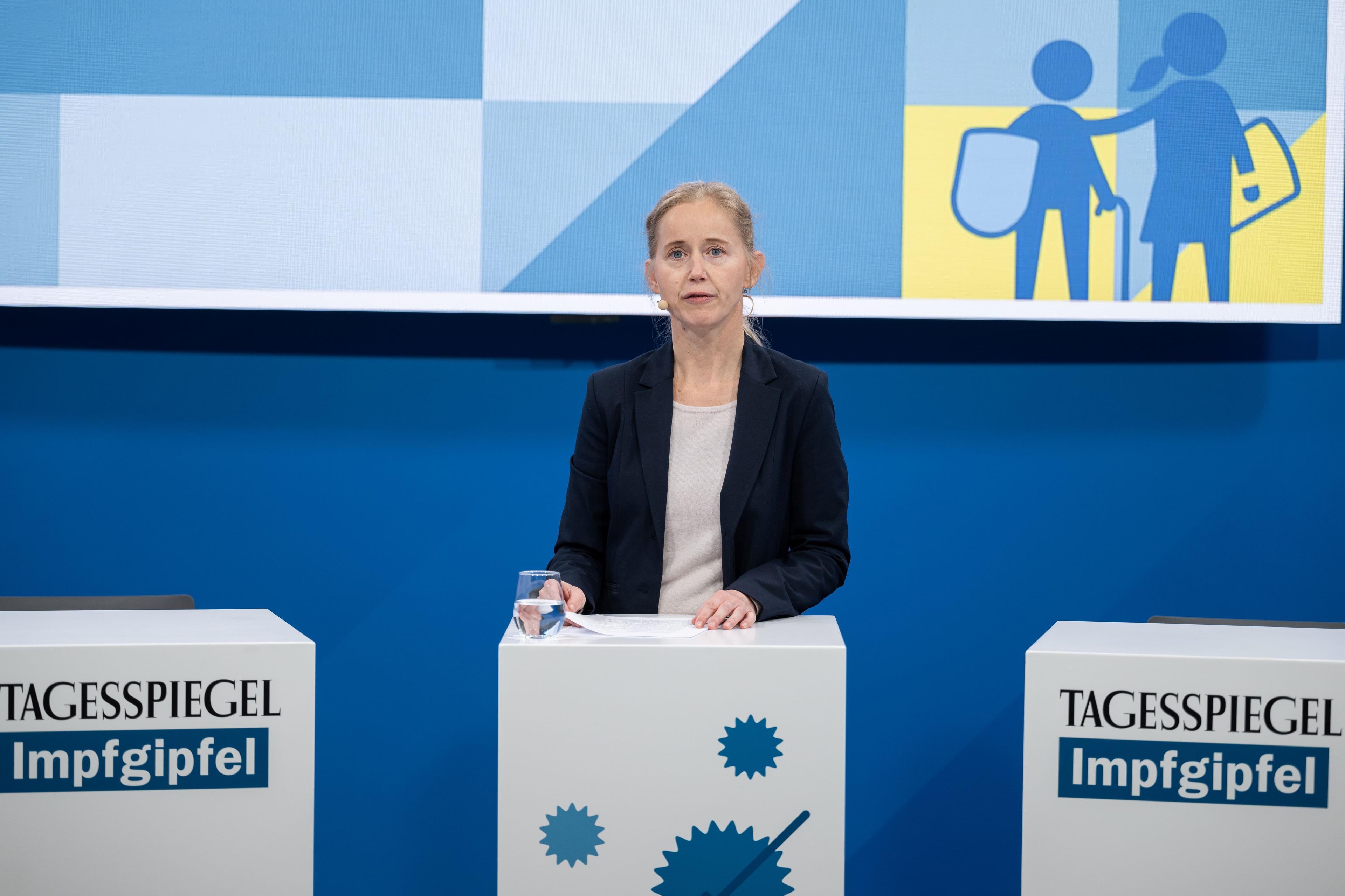 Frau steht hinter einem Rednerpult.