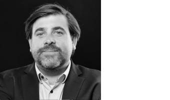 Ein Mann mit kurzen Haaren, der einen Anzug trägt.