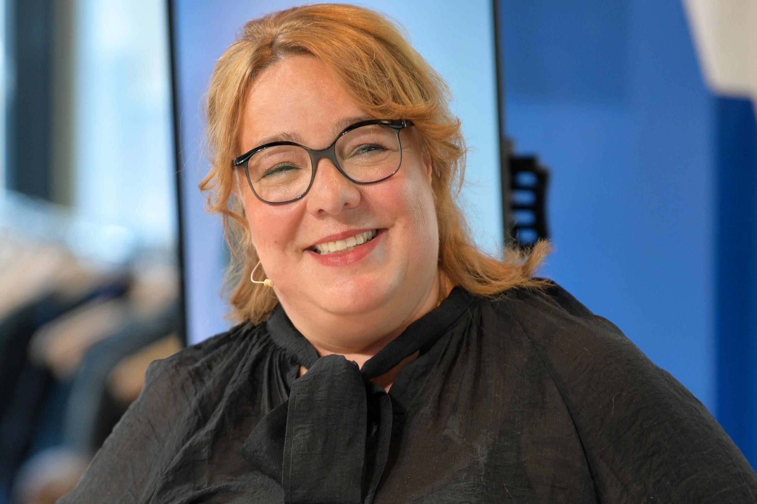 Ein Frau mit langen Haaren, die eine Brille trägt.
