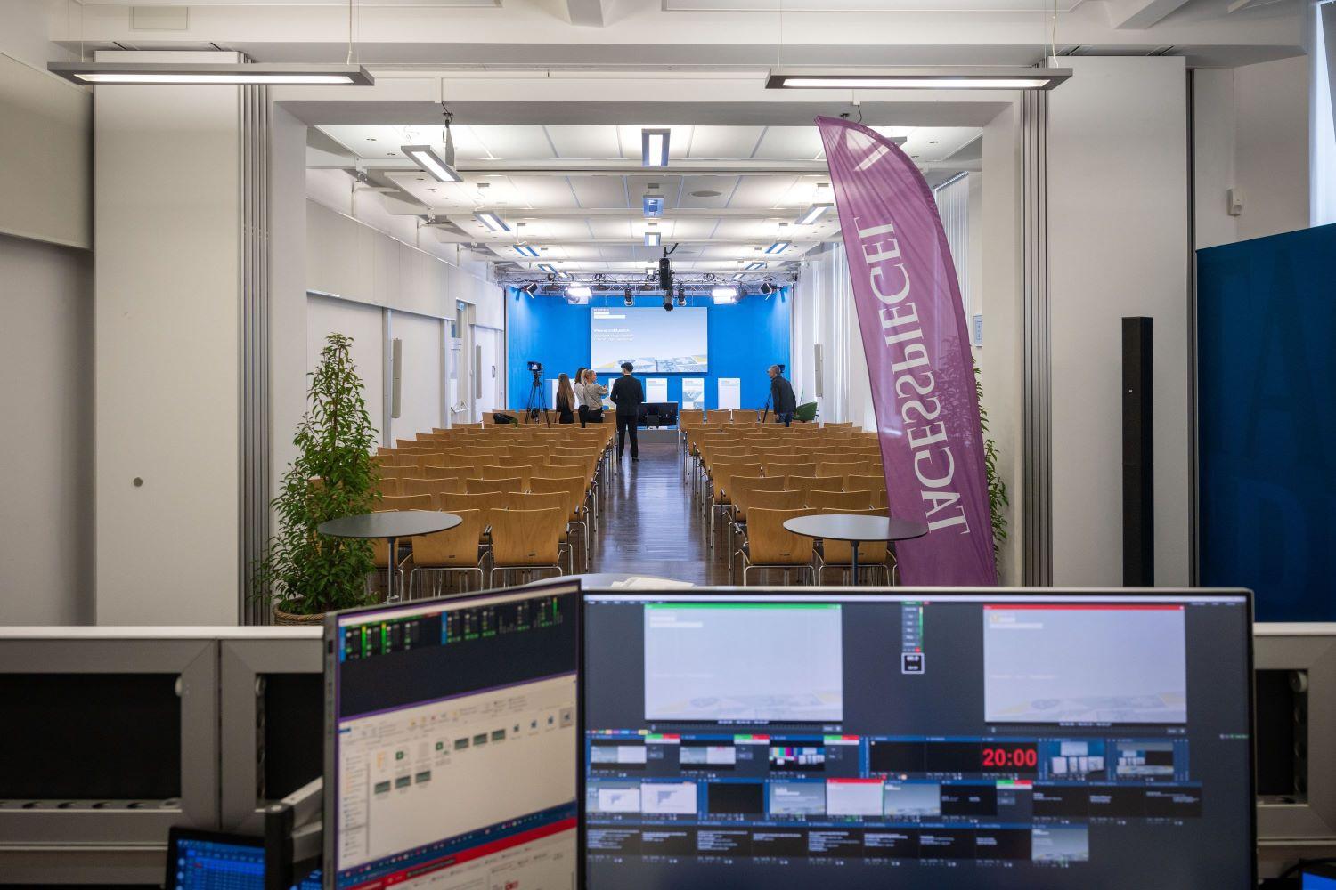 Ein Konferenzraum mit Stühlen, Tischen und Technik im Vordergrund.