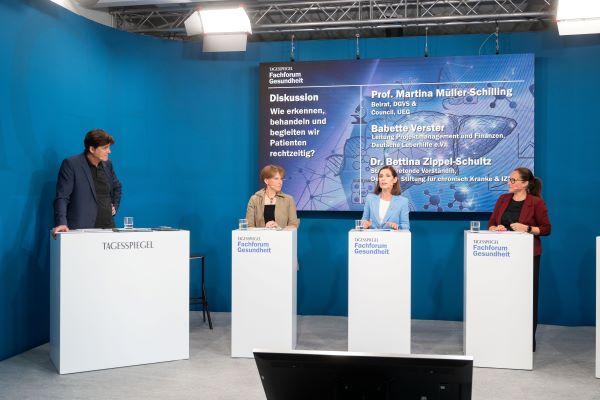 Ein Mann und drei Frauen stehen auf der Bühne und sprechen miteinander.
