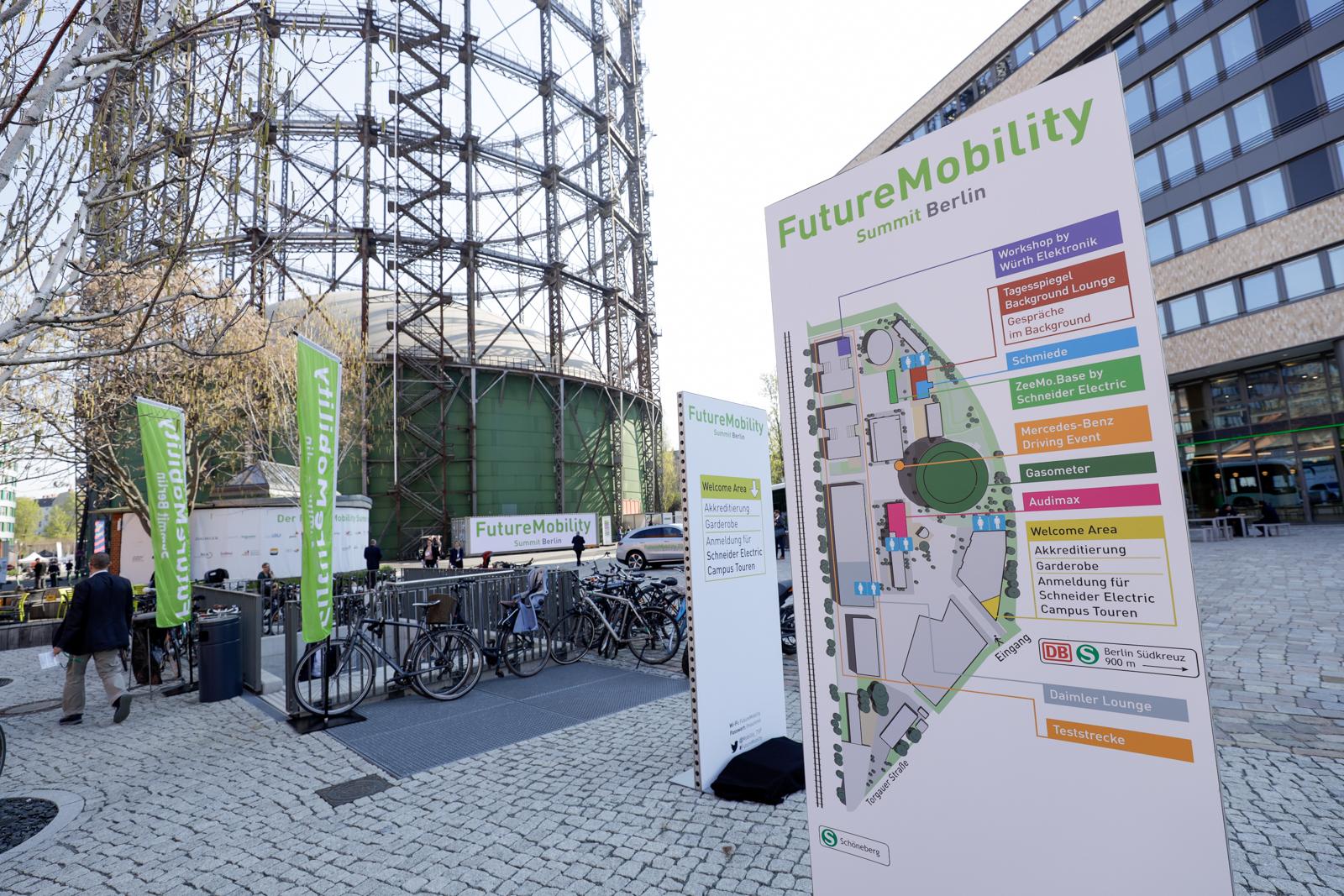 Eventbereich des FutureMobility Summit Berlin mit Lageplan, Bannern und Fahrrädern.