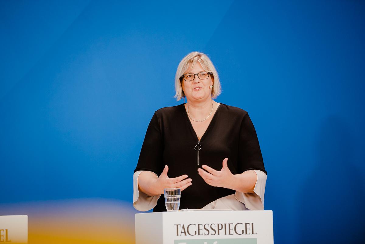 Eine Person steht hinter einem Rednerpult.